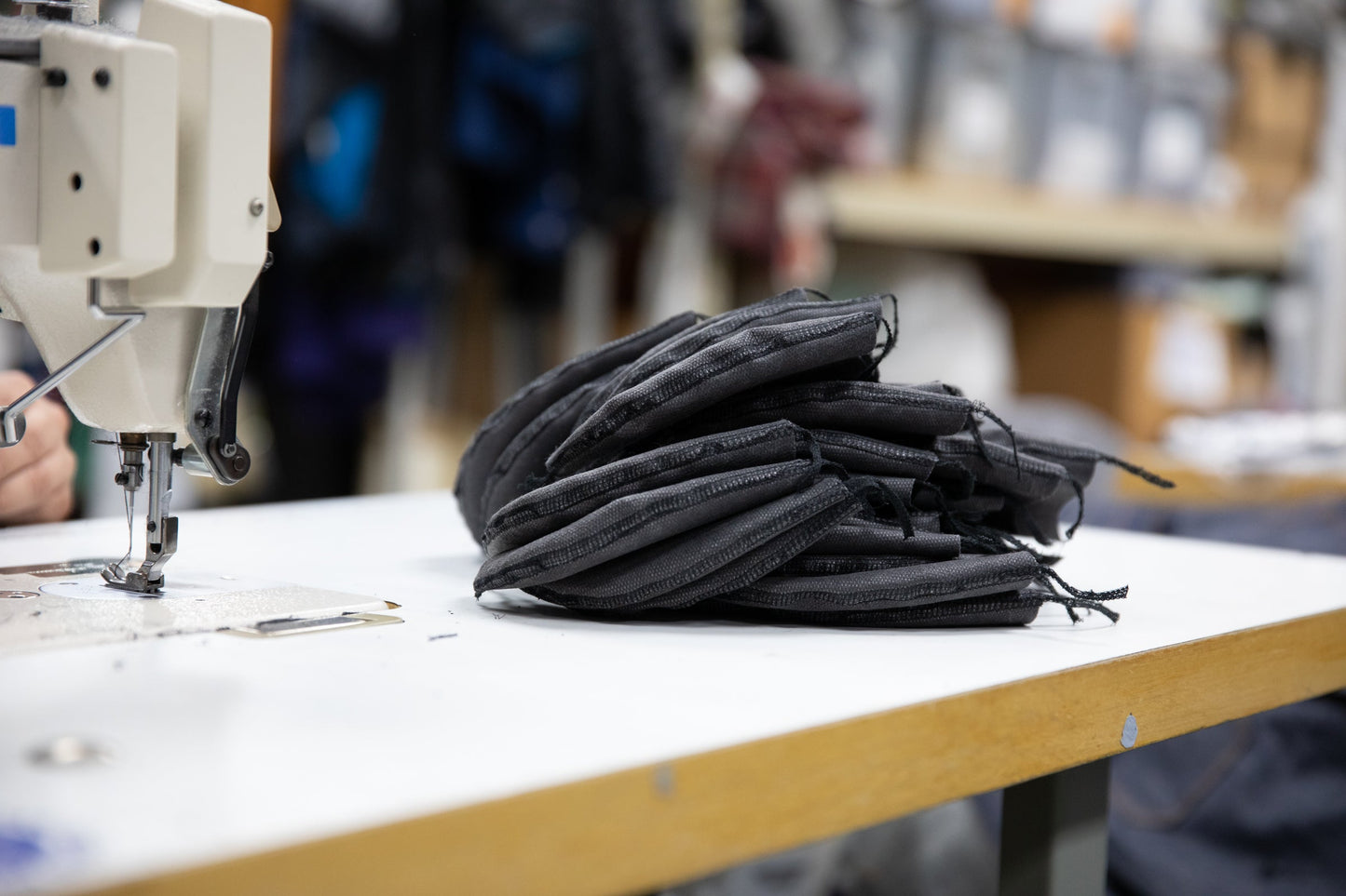 queue of grey masks in the sewing room waiting to be sewn