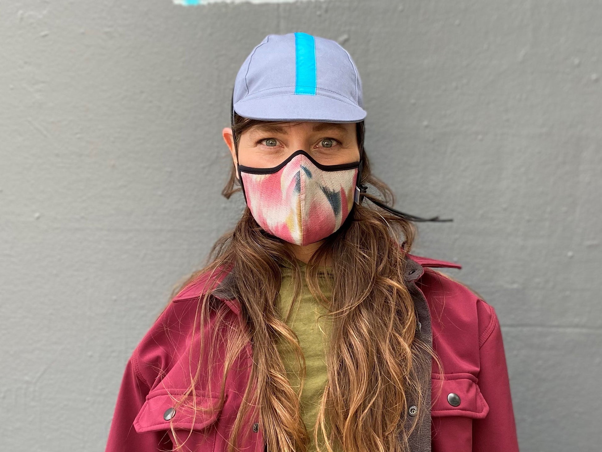 Muriel is wearing the 4-panel cotton cap in blue-grey with cyan ribbon and the cherry Shibori wing spots cotton mask